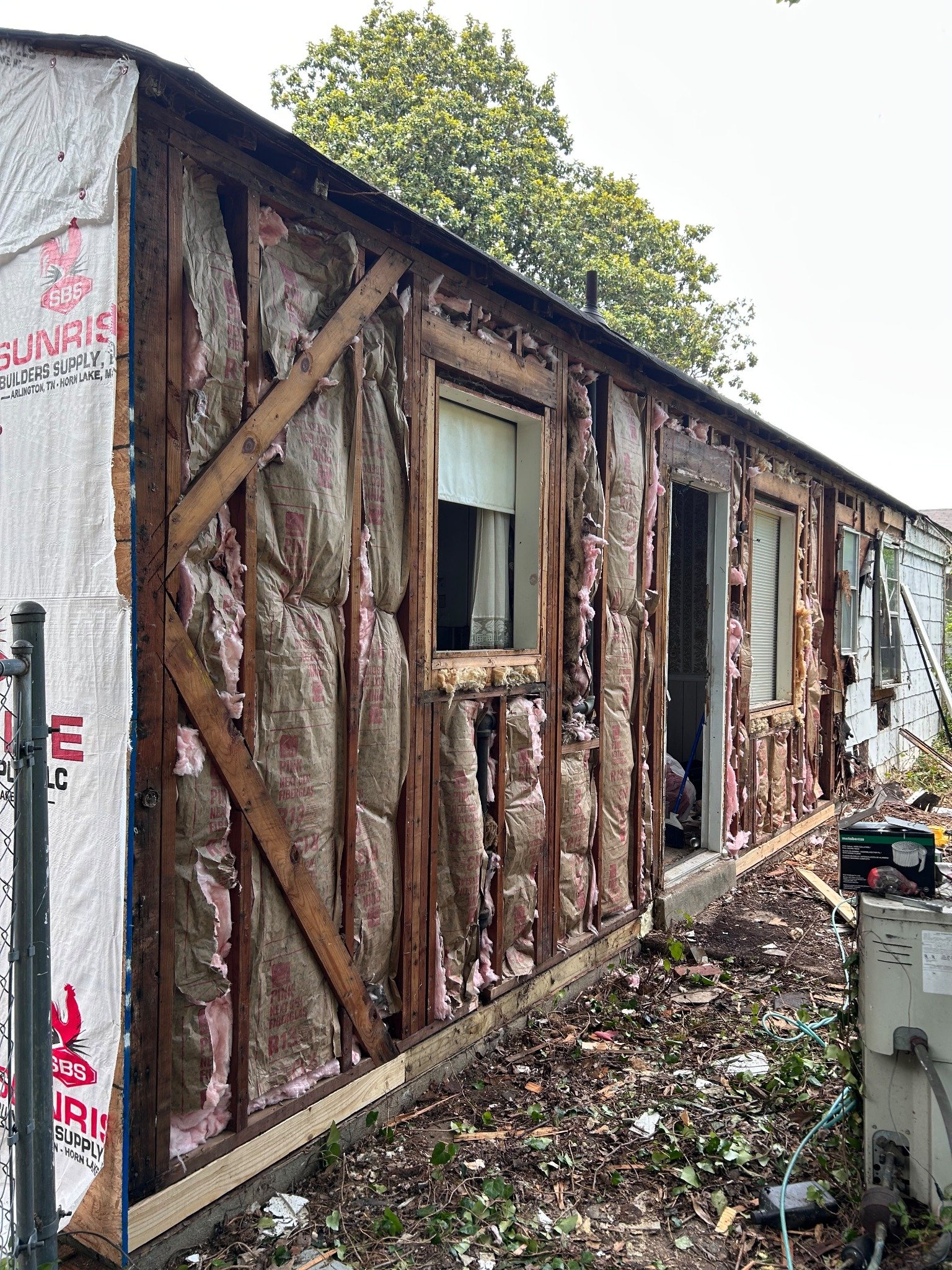 Before — exterior with insulation and framing exposed